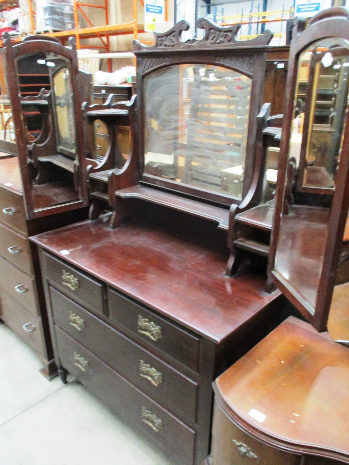 A mahogany stained four drawer triple swing back dressing table 106cm long