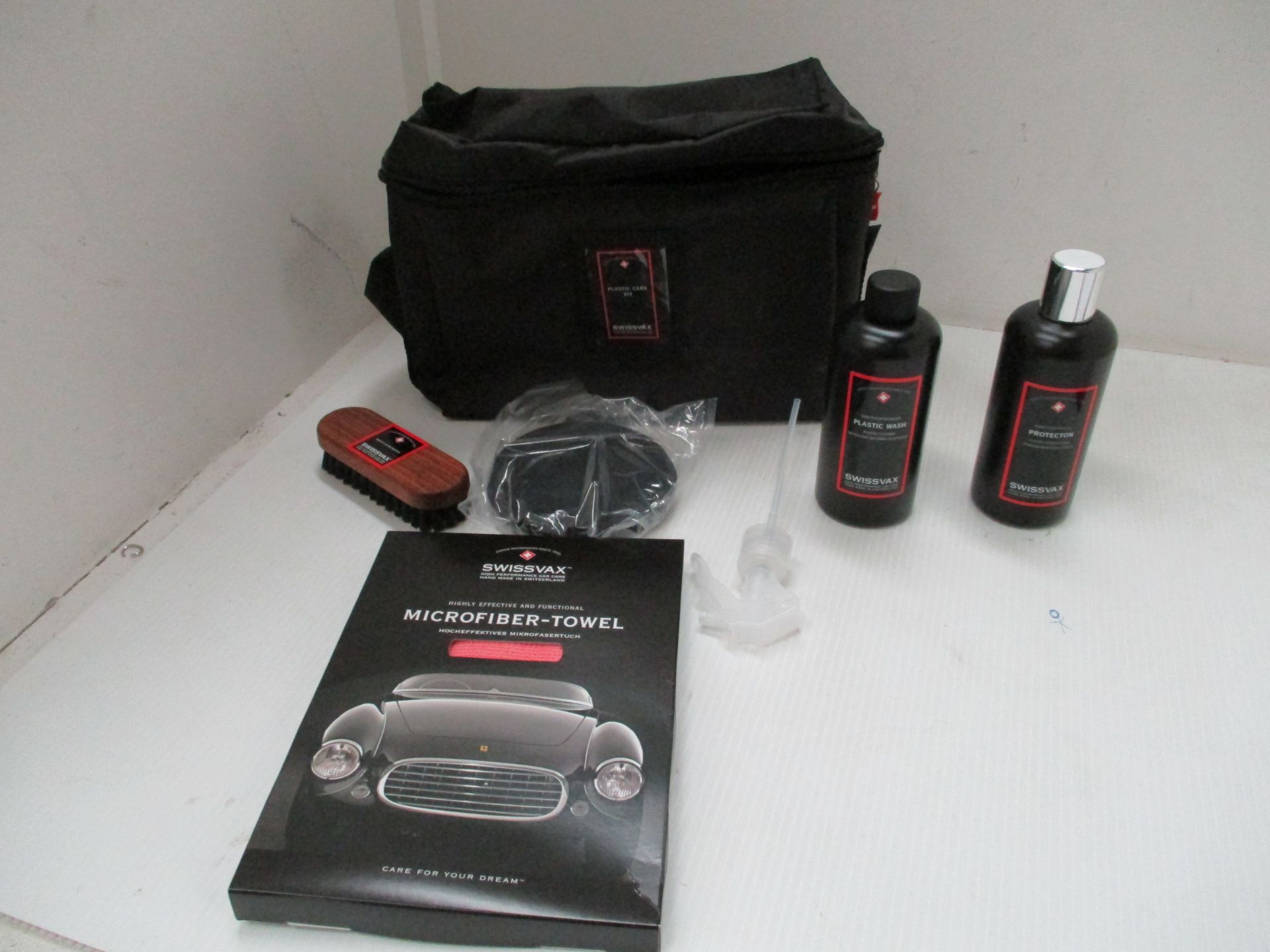 A Swissvax high performance car plastic care kits comprising microfibre towel, brush,