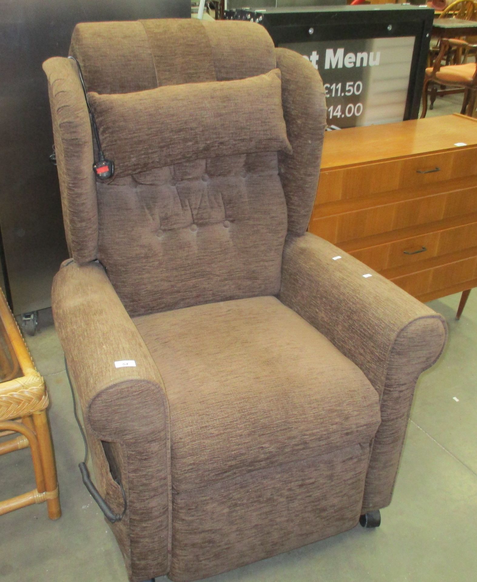 A brown upholstered electrically operated recliner armchair