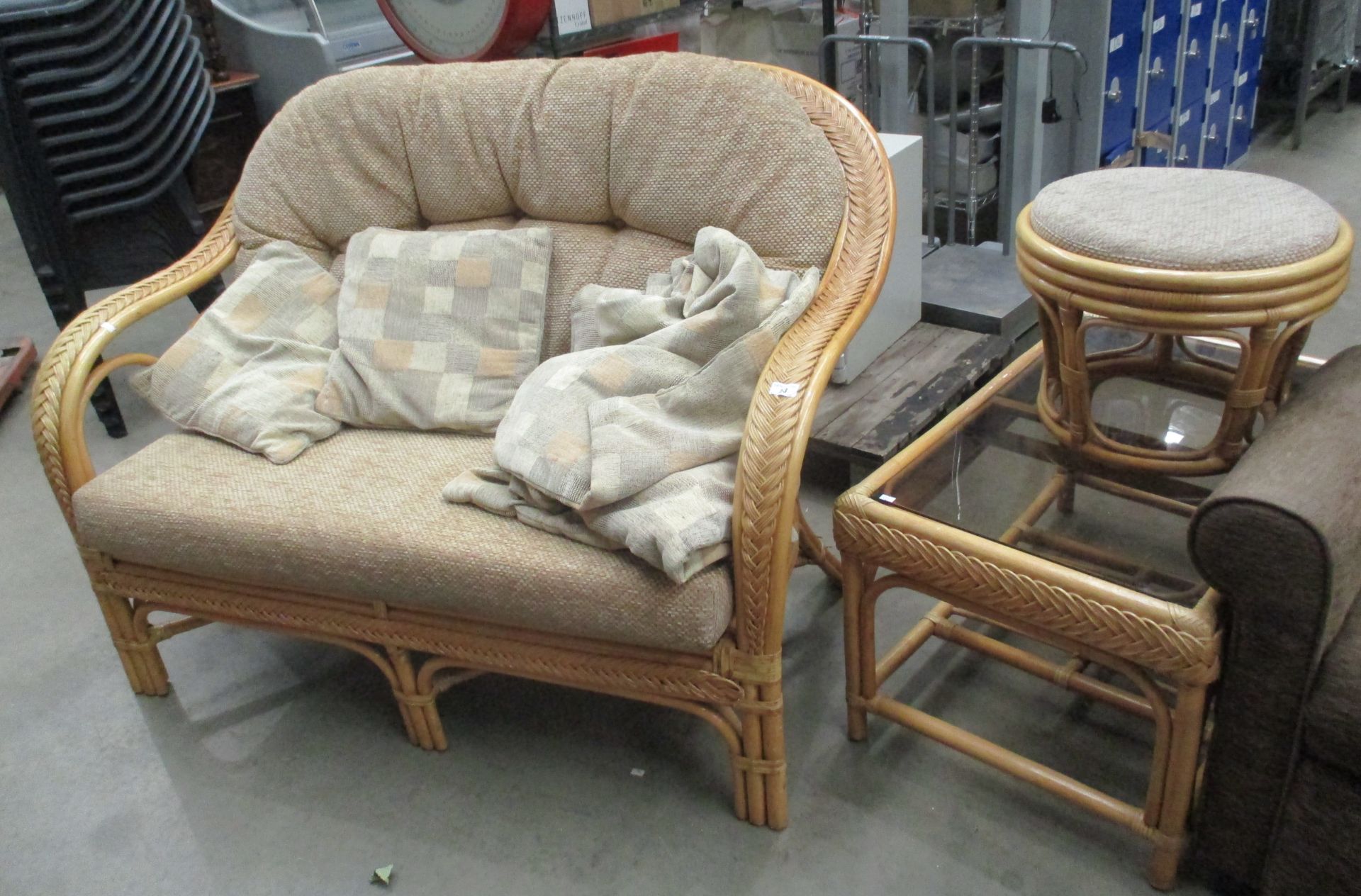 A light cane conservatory suite comprising two seater sofa with brown upholstery,