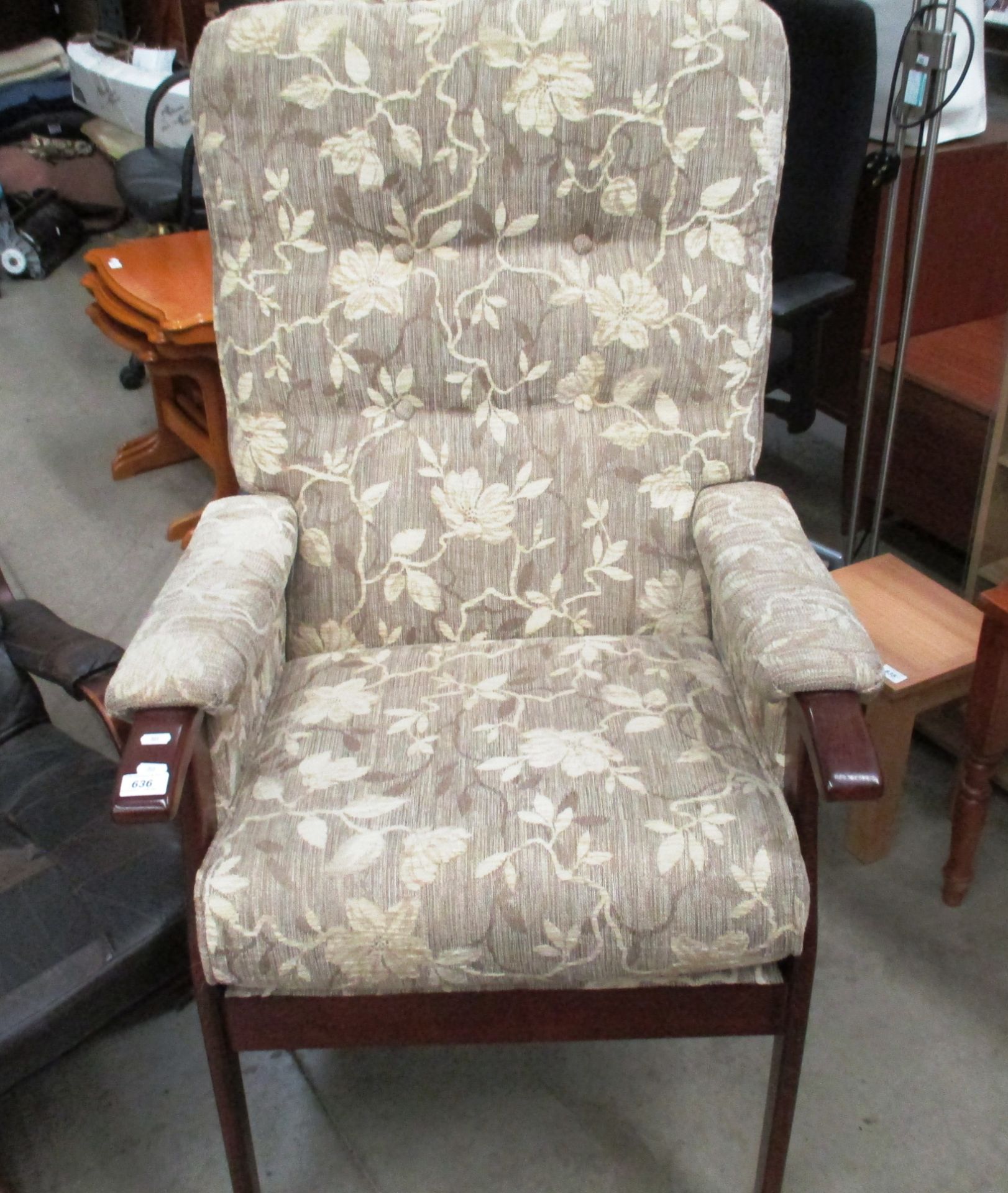 A light brown floral patterned upholstered armchair