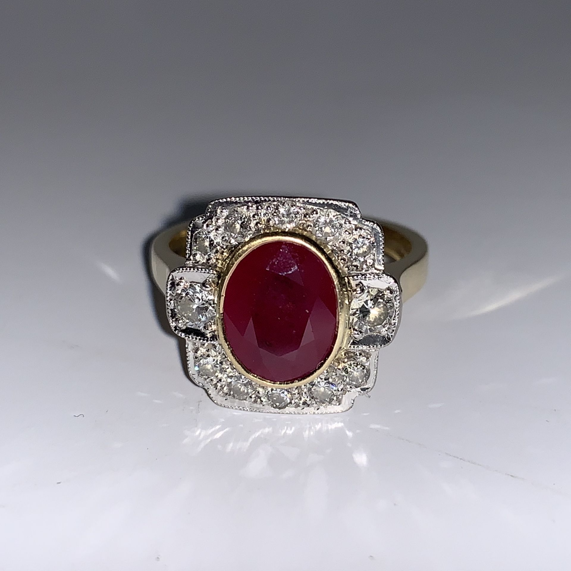 An Art Deco style ruby and diamond ring complete with valuation certificate which details the ring