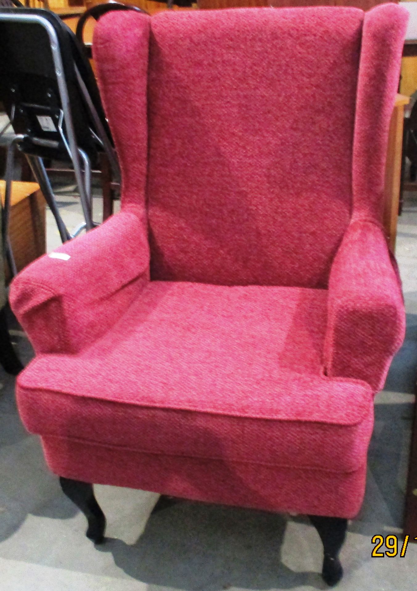 A red upholstered wing back armchair