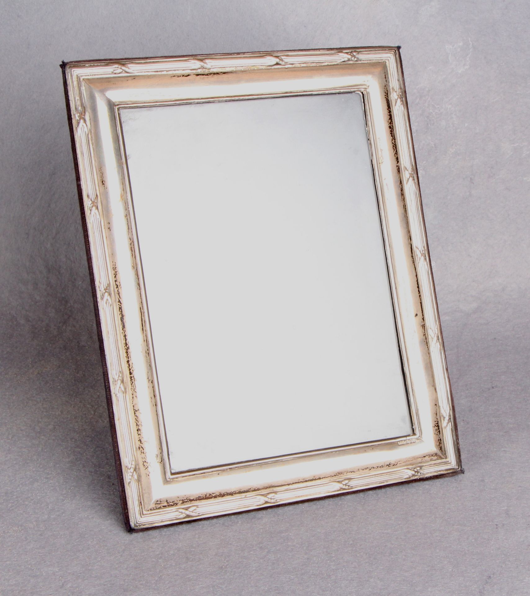 A rectangular picture frame with ribbon tied and reeded border, strut support,