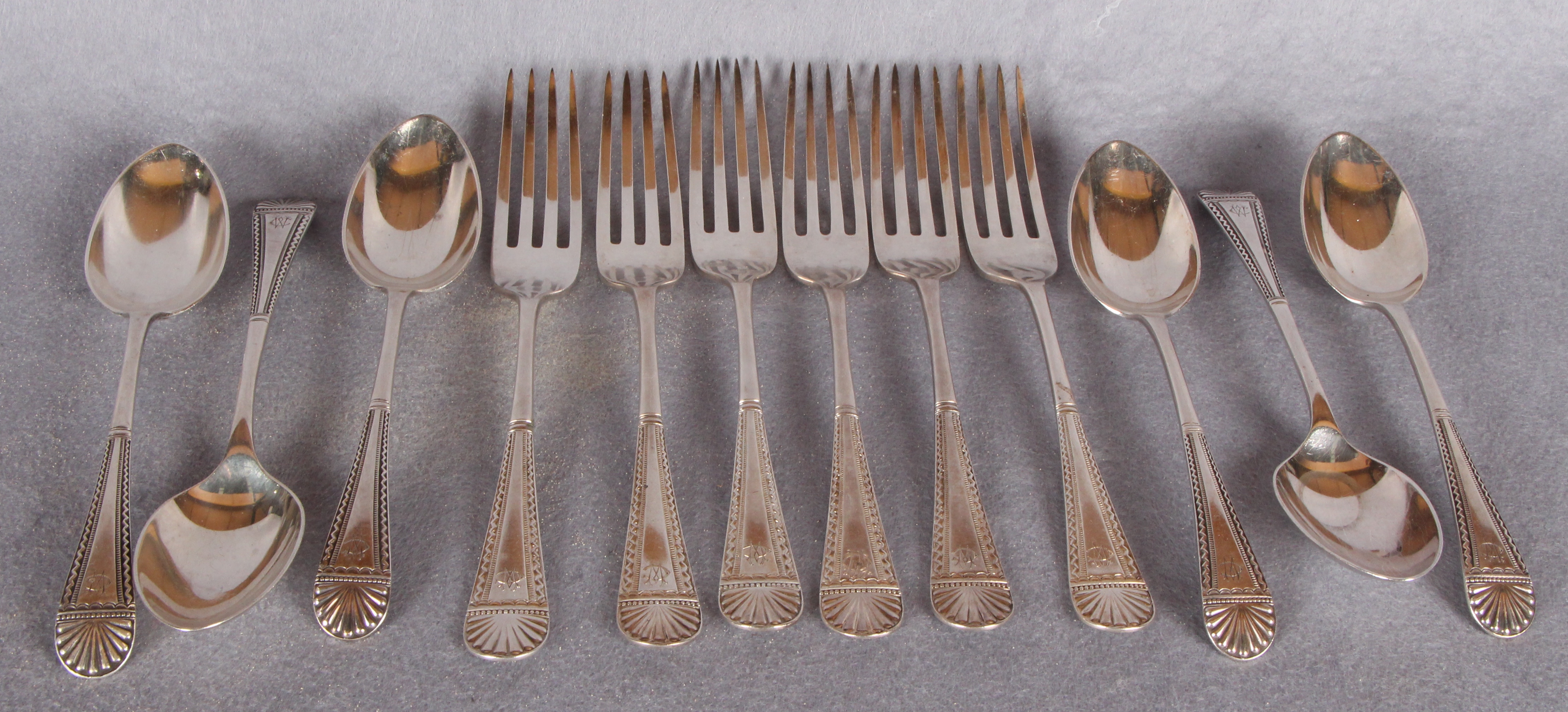 A set of six Edwardian table forks and a matching set of six dessert spoons,