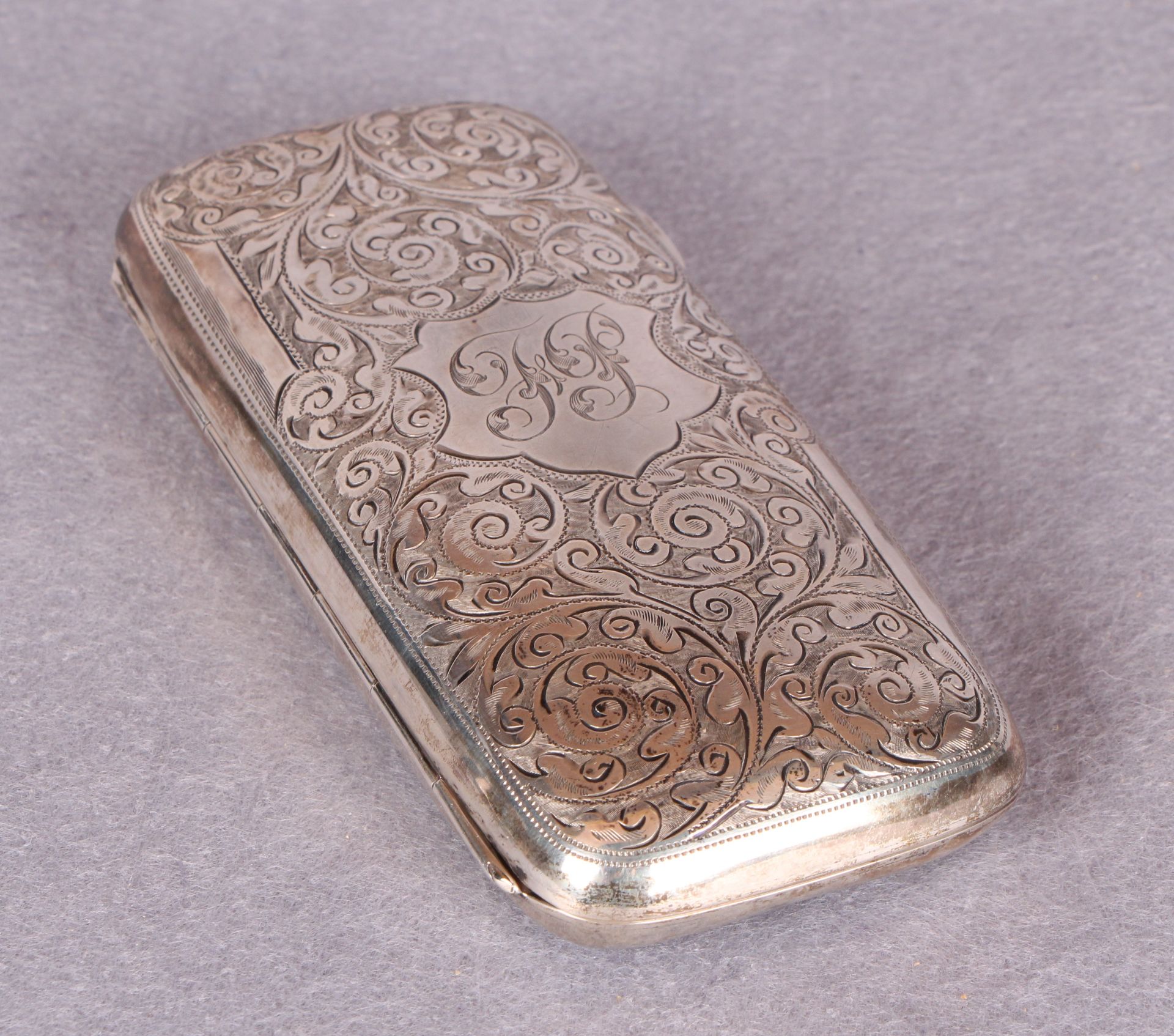 An Edwardian cigar case, overall engraved with foliage, the interior gilt,