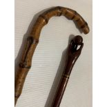 Mahogany walking stick with hand and ball finial and another walking stick