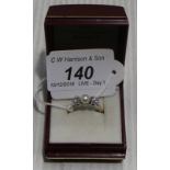 An 18ct gold ring set with centre pearl and two claw set diamonds