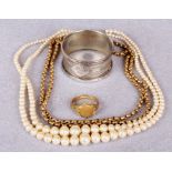 A silver napkin ring, a paste pearl necklace,