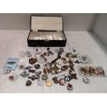 Large collection of assorted badges contained in a small brown patterned jewellery box
