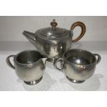 A Liberty Tudric pewter tea set comprising teapot, sugar bowl and cream,