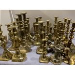 A large collection of brass candlesticks, etc.