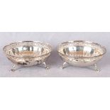 A pair of circular bon-bon dishes with pierced rims and semi fluted bases, three claw and ball feet,