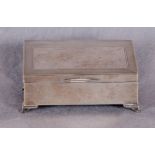 An engine-turned silver cigarette box with hinged, sloping lid, cedar lining,
