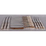 A set of eight silver handled table knives with loaded handles and stainless blades,