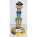 An 18th century Chinese Canton enamel candlestick reserved with panels of figures (considerable