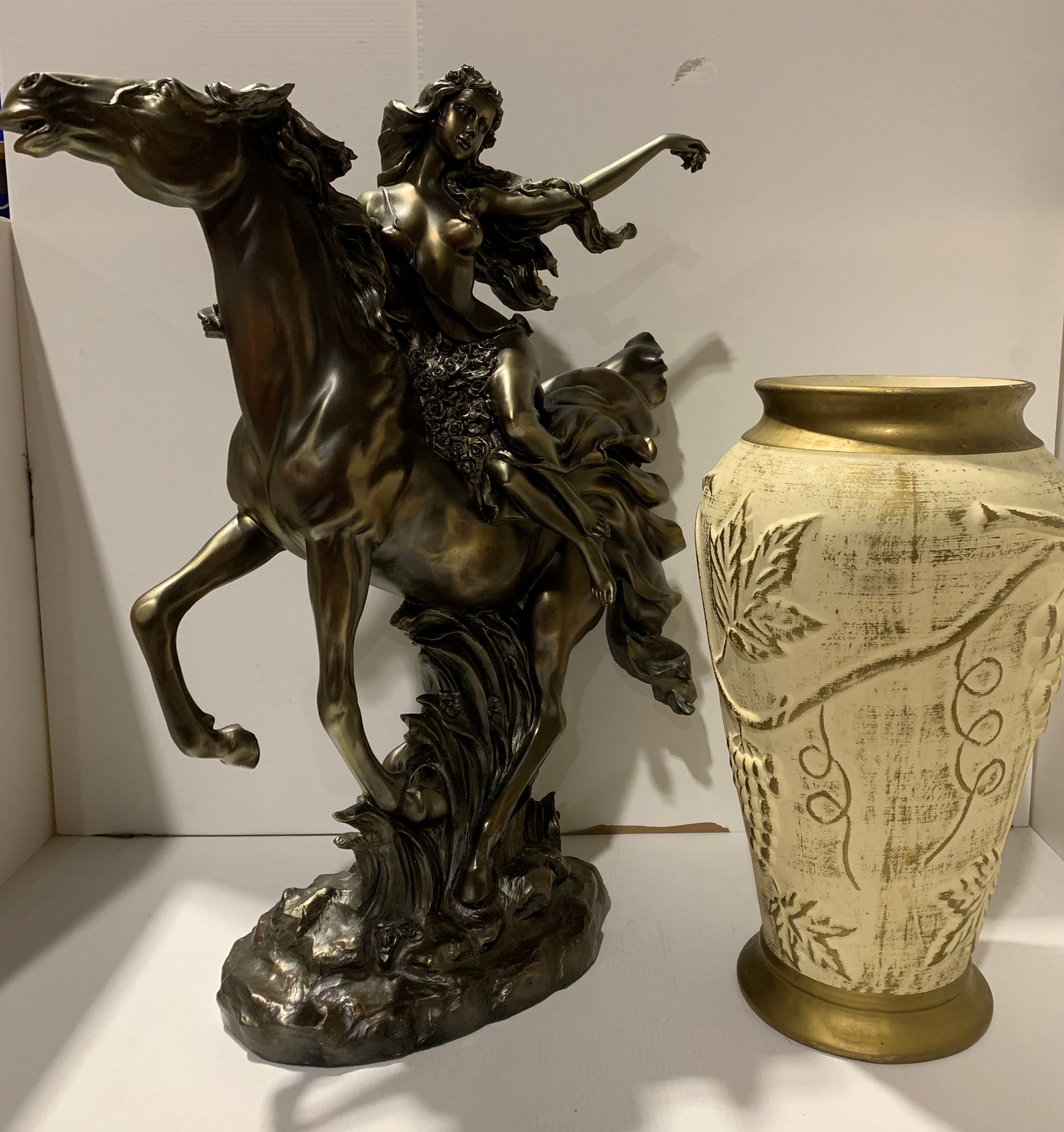 A composition gold coloured statue of a maiden on a horse,