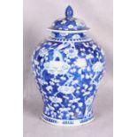 A Chinese porcelain baluster vase and cover, blue and white painted with prunus blossom,