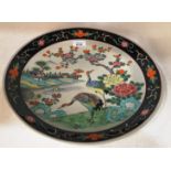 A Chinese "famille rose" circular wall plate, painted with cranes in a river landscape, modern, 37.