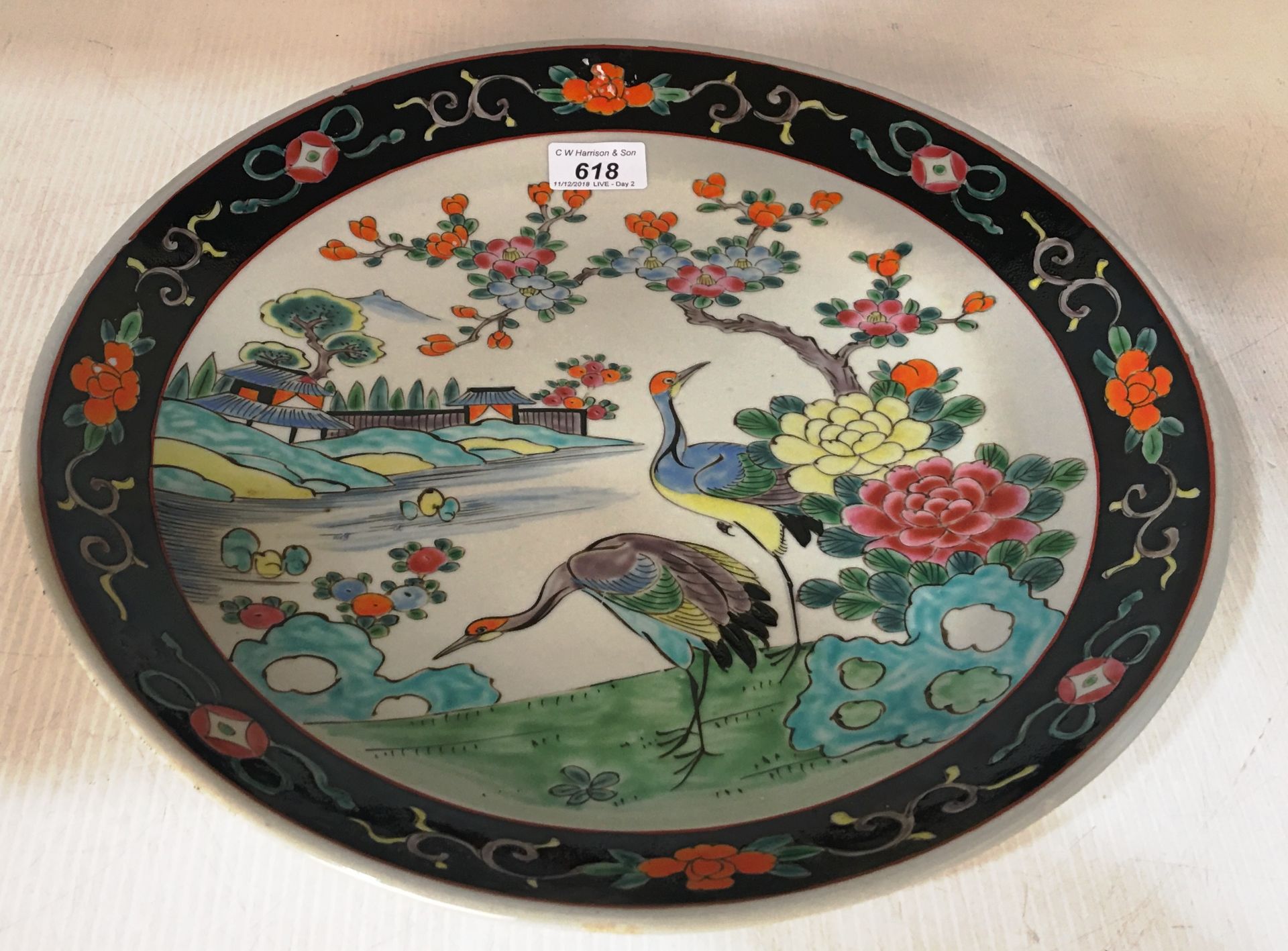 A Chinese "famille rose" circular wall plate, painted with cranes in a river landscape, modern, 37.