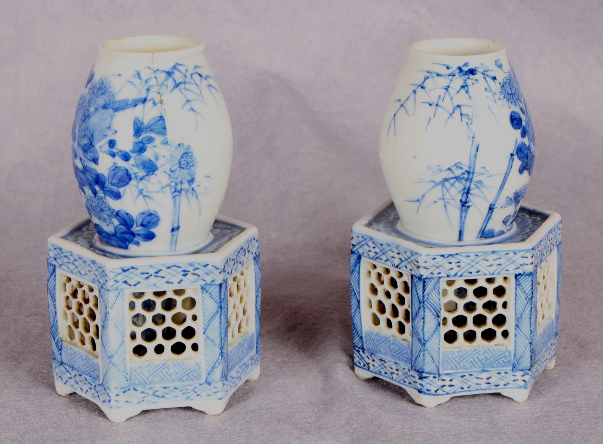 A pair of Japanese blue and white porcelain vases, each on a reticulated hexagonal section base,