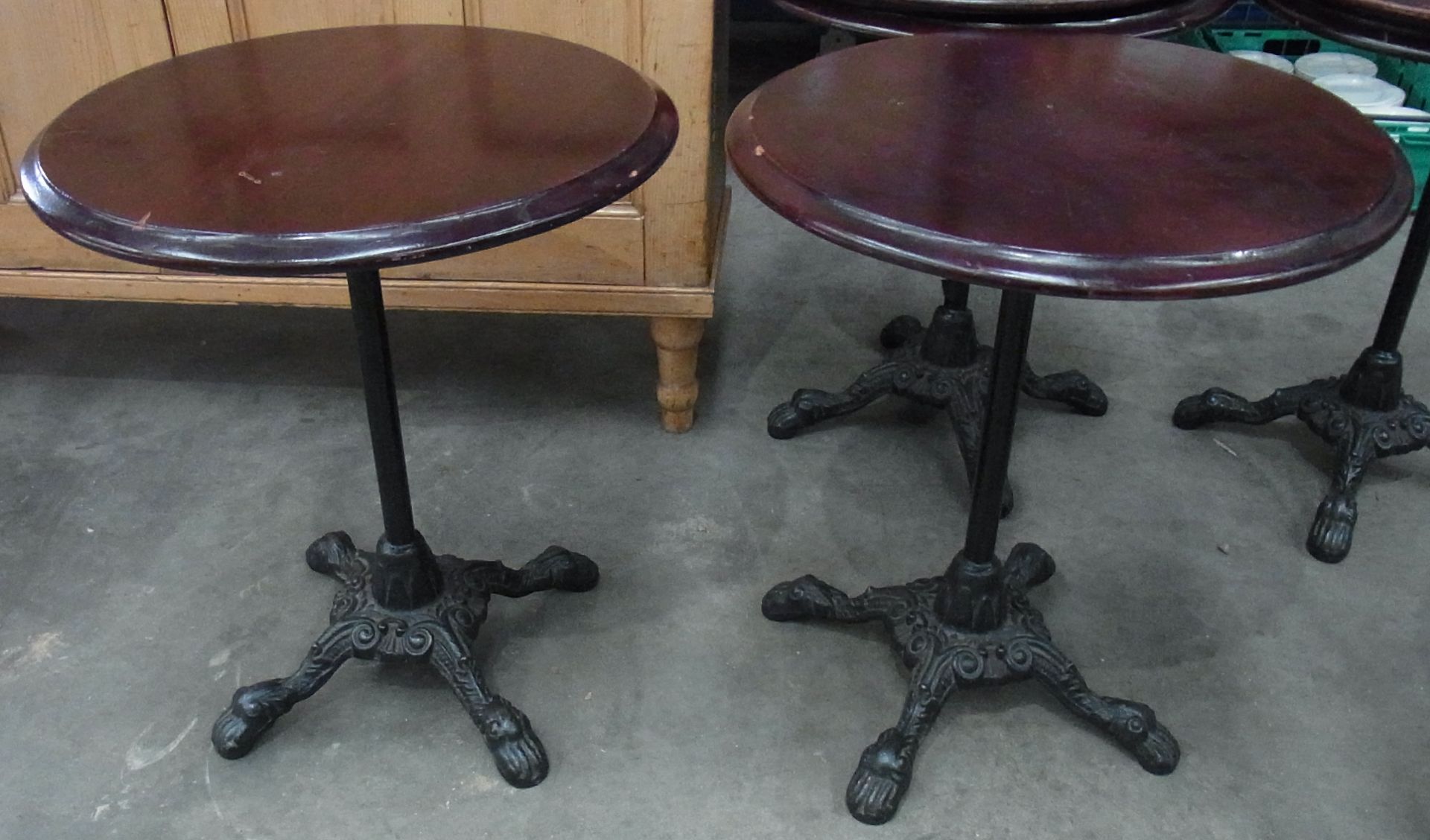 Two circular mahogany topped bar table on four legged single column cast metal stand- 23" dia.