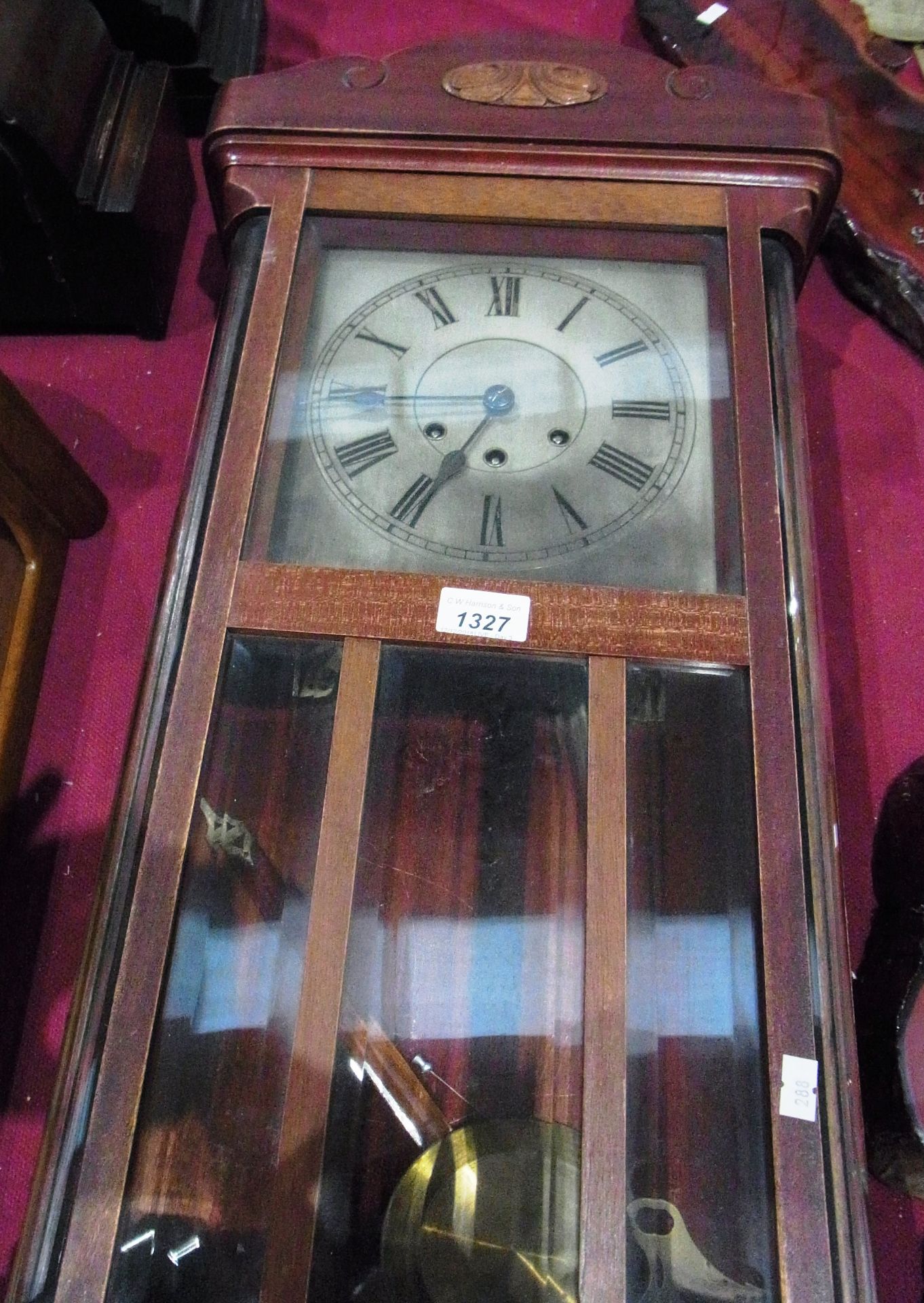 Mahogany cased wall clock with pendulum and key 31"