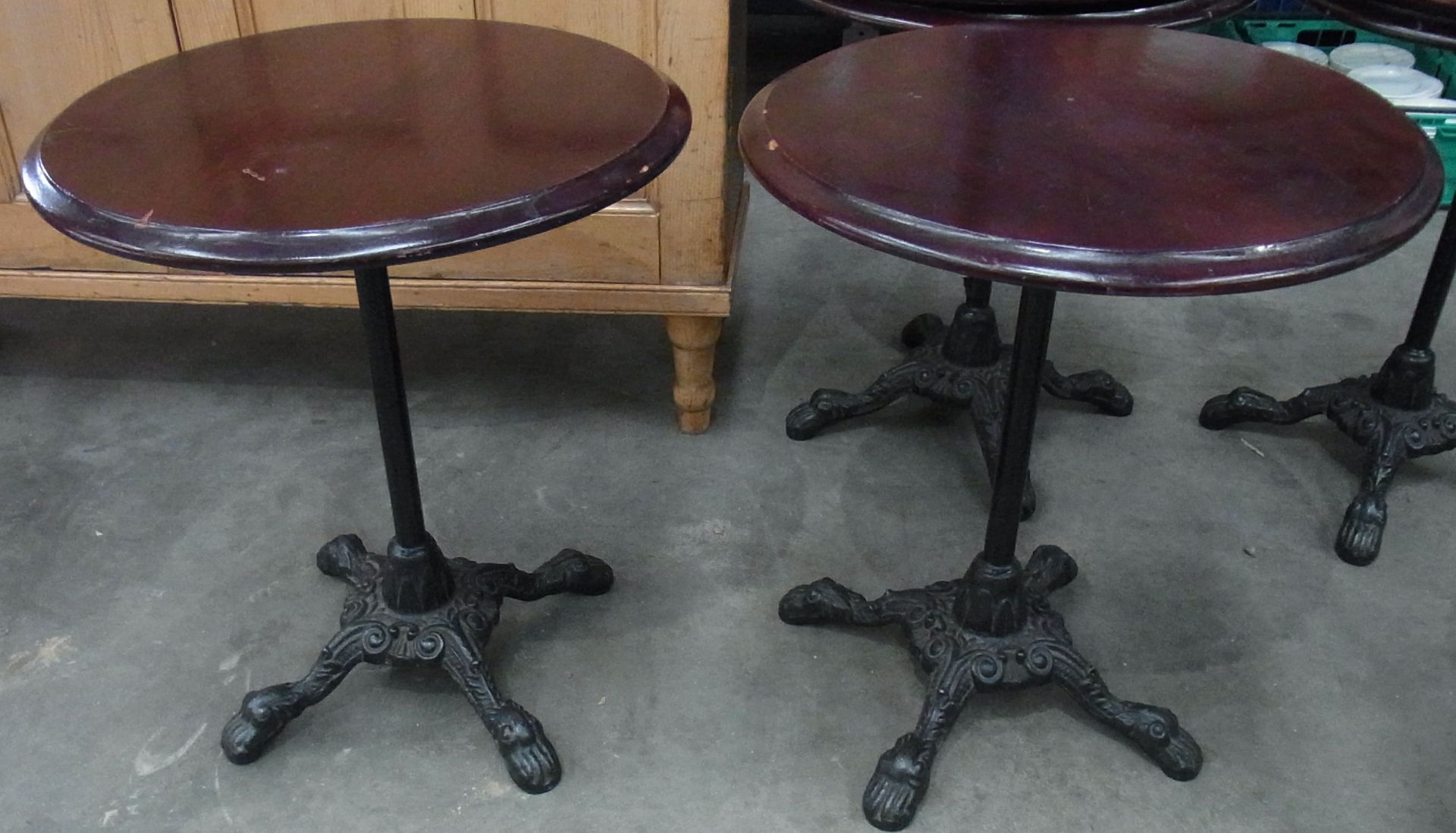 Two circular mahogany topped bar table on four legged single column cast metal stand- 23" dia.