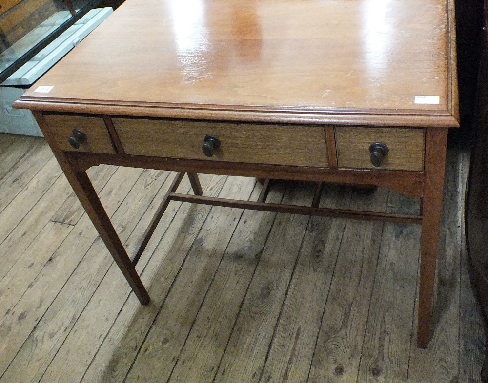 A mahogany three drawer side table on square tapered legs