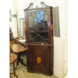 An Edwardian mahogany floor standing corner cabinet with fretted cornice,