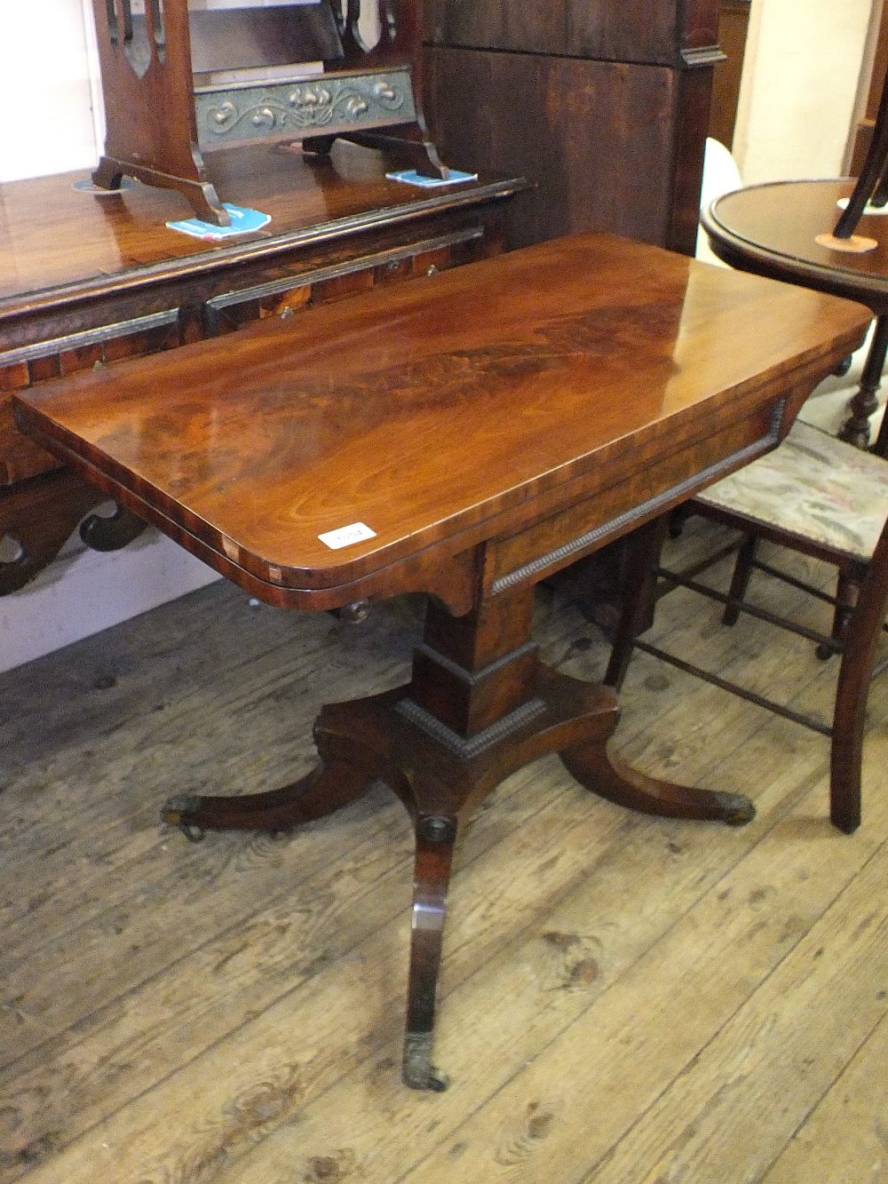 A 19th Century mahogany folding top card table of quadruple supports