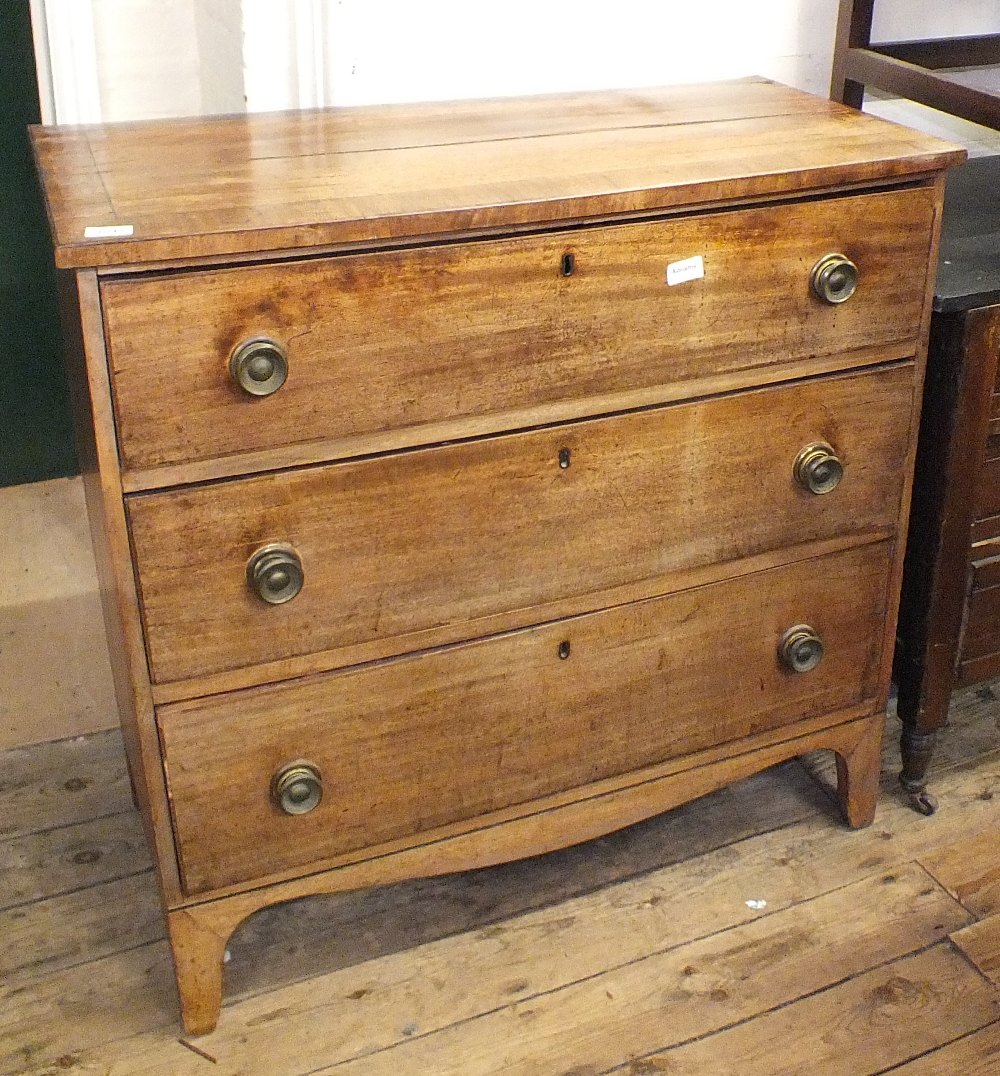 A Georgian mahogany three drawer chest on bracket feet