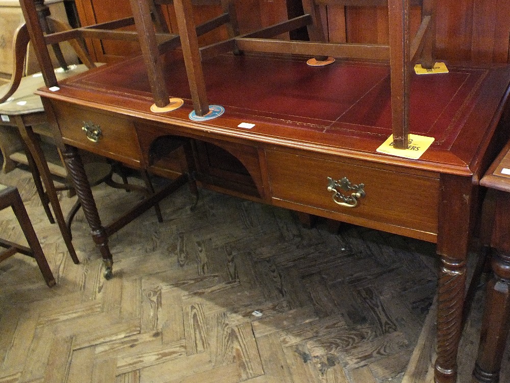 A mahogany two drawer writing desk with maroon tooled leather top on spiral twist legs