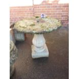 A circular concrete garden table