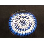 A glass paperweight with blue and white Millefiori canes