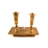 A pair of unusual aesthetic period brass candlesticks embossed with eight horse and rider figures