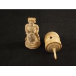 A carved ivory chess piece and a bone spinning top