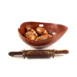 A carved wooden bowl containing decorated gourds and other items