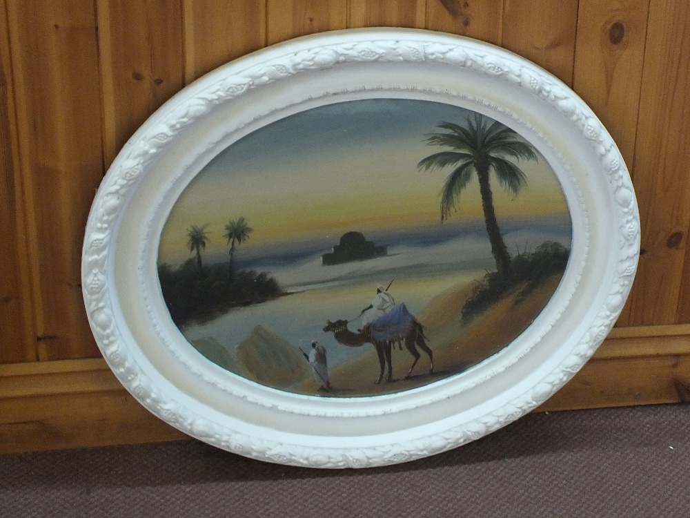 An oval oil on board of a desert scene with camel and Arabs,