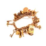 A 9ct gold charm bracelet hung with various 9ct gold,
