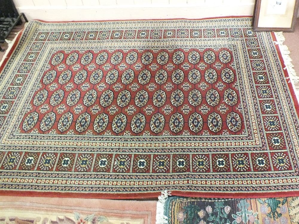 Two machine made Persian pattern rugs plus a circular Indian floral rug