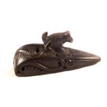 A carved item with animal finial and holes for attachment