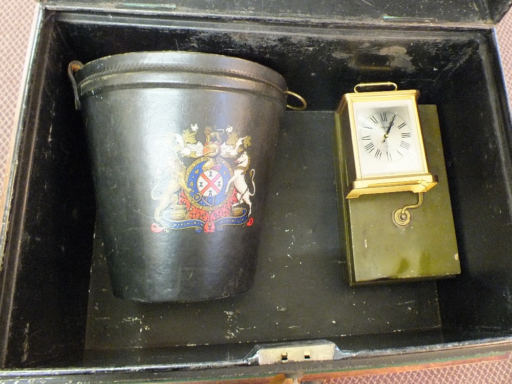 A tin trunk containing a leather fire bucket, cash tin,