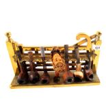 A brass pipe rack containing Meerschaum and other pipes including silver banded lady's head