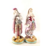 A pair of 19th Century continental figurines of a lady and a gentleman with polychrome floral