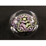 A cut glass paperweight with mauve and yellow Millefiori canes