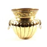 A large Arts and Crafts brass jardiniere with gadrooned and floral embossed decoration and twin