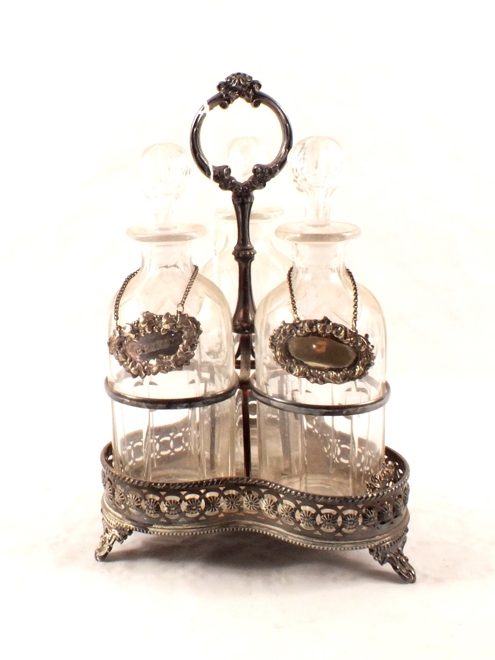 A silver plated three decanter stand with cut glass decanters