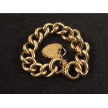 A 9ct gold heavy curb link bracelet with heart shaped padlock clasp
