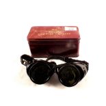 A pair of Bocal industrial goggles and lenses in tin
